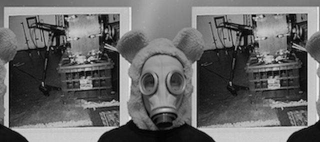 Me wearing a bear costumer with a gas mask and black t-shirt on in front of an over exposed polaroid and a background of space